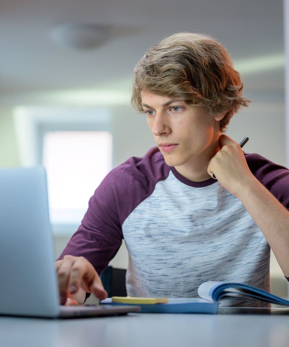 A Year 9 pupil working through a problem at his laptop during a morning session
